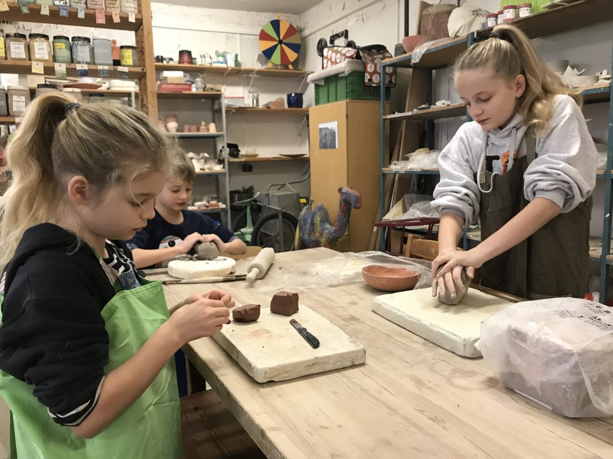 Drei Kinder beim Töpfern in der Keramikwerkstatt.