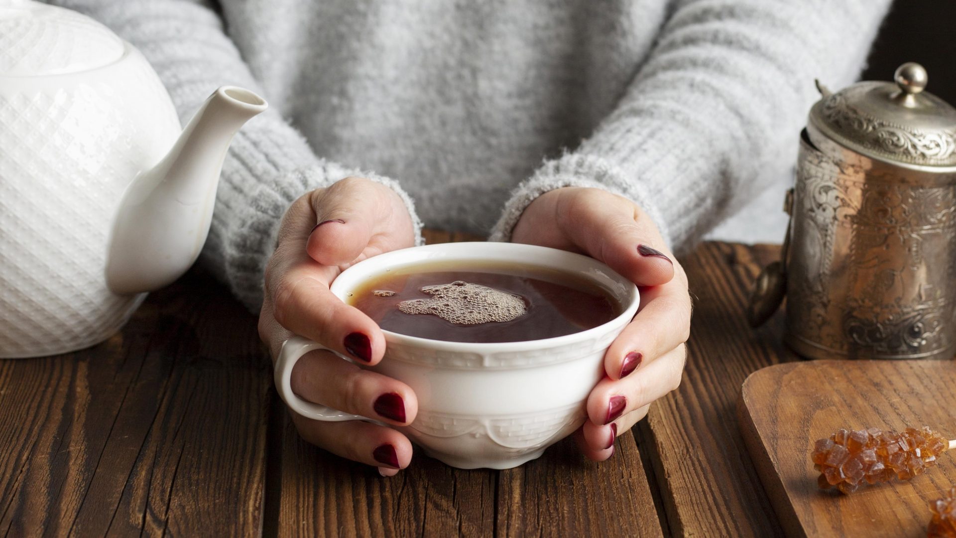 Zwei Hände wärmen sich an einer Tasse Kaffee.